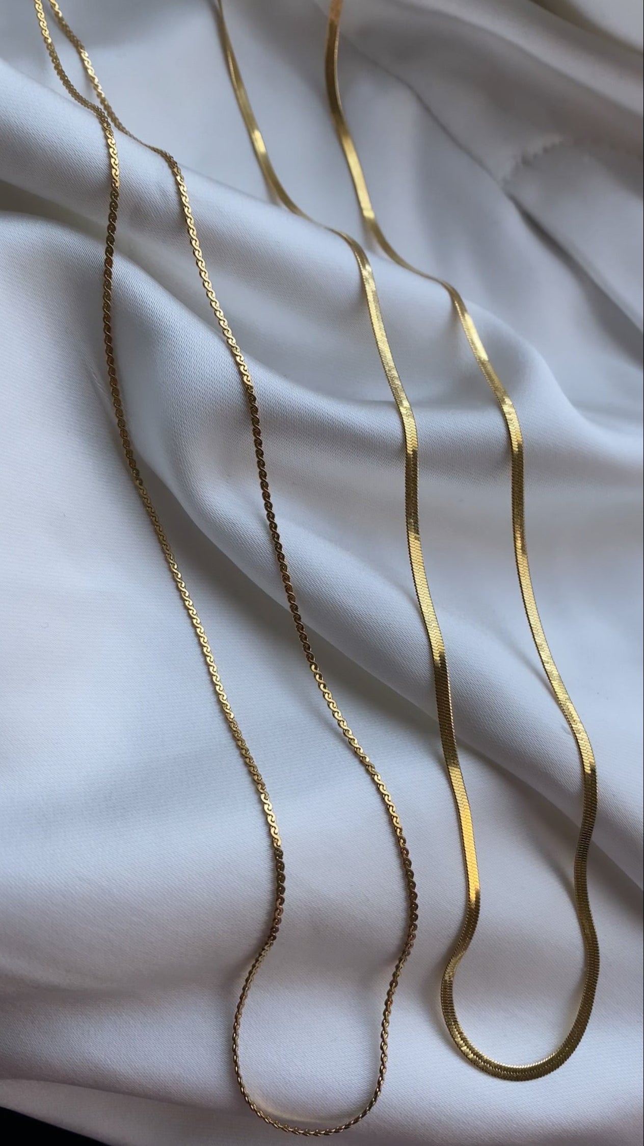Gold chain on a white fabric background