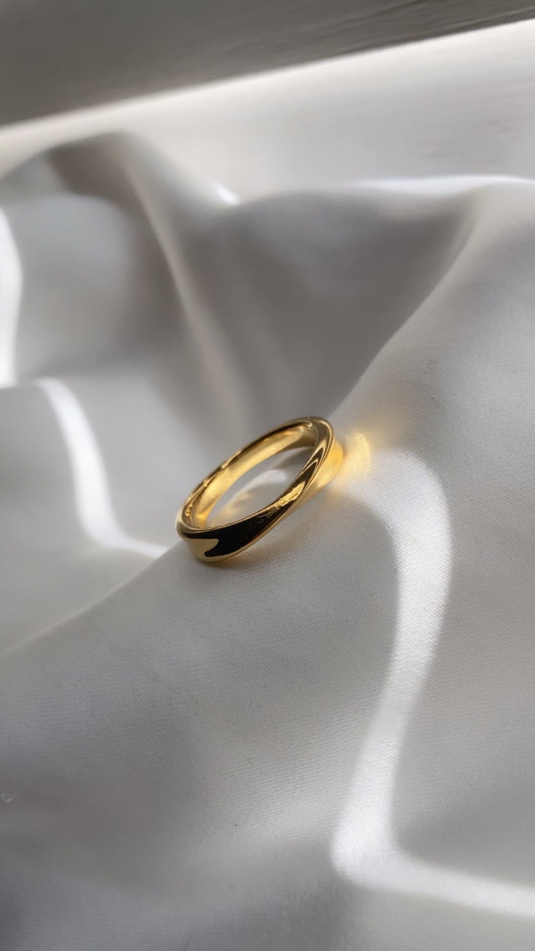 Gold ring on a white fabric surface
