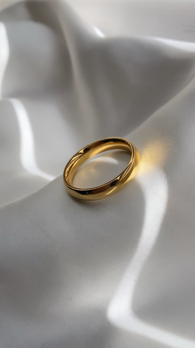 Gold ring on a white fabric surface