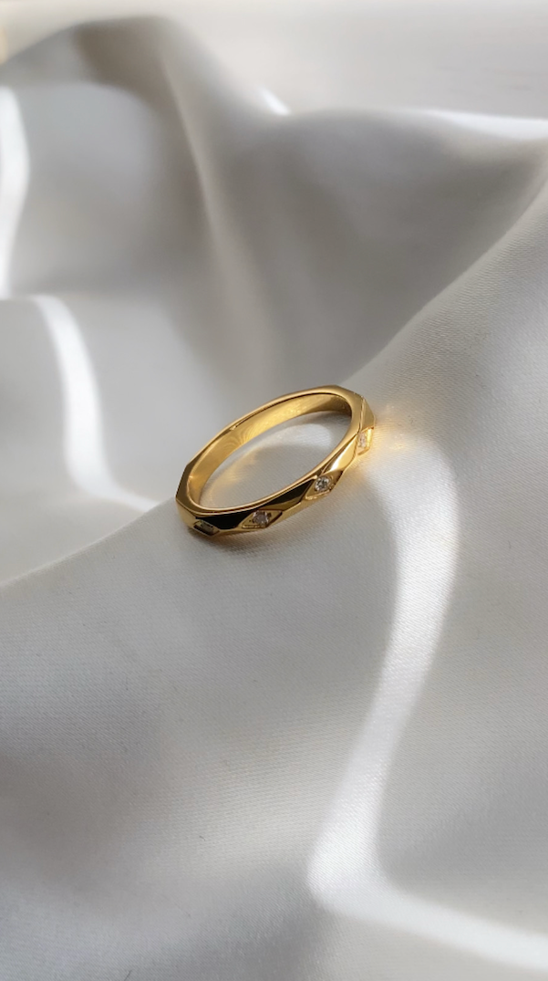 Gold ring on a white fabric surface