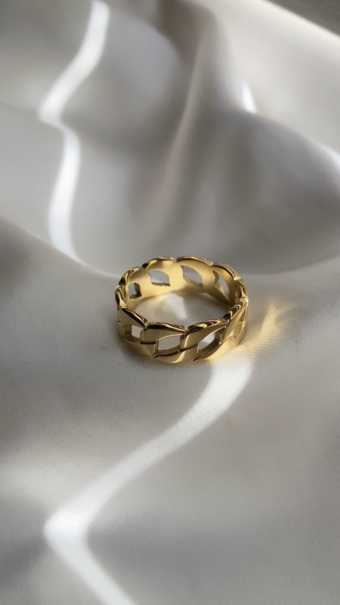 Gold ring on a textured white surface