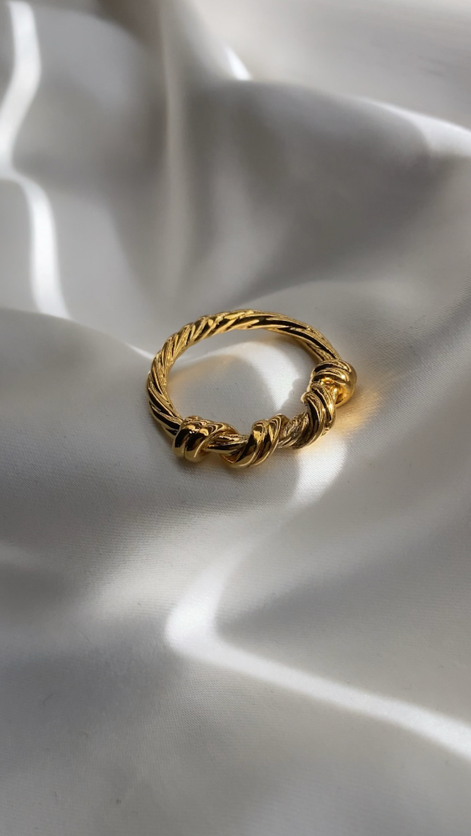 Gold ring on a white fabric surface