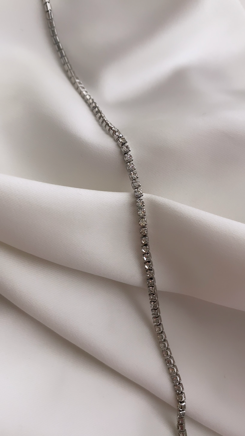 Silver bracelet on a white fabric background