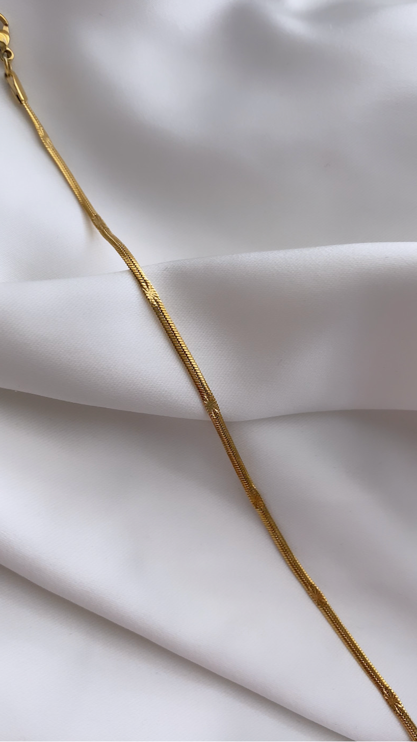 Gold chain on a white fabric background