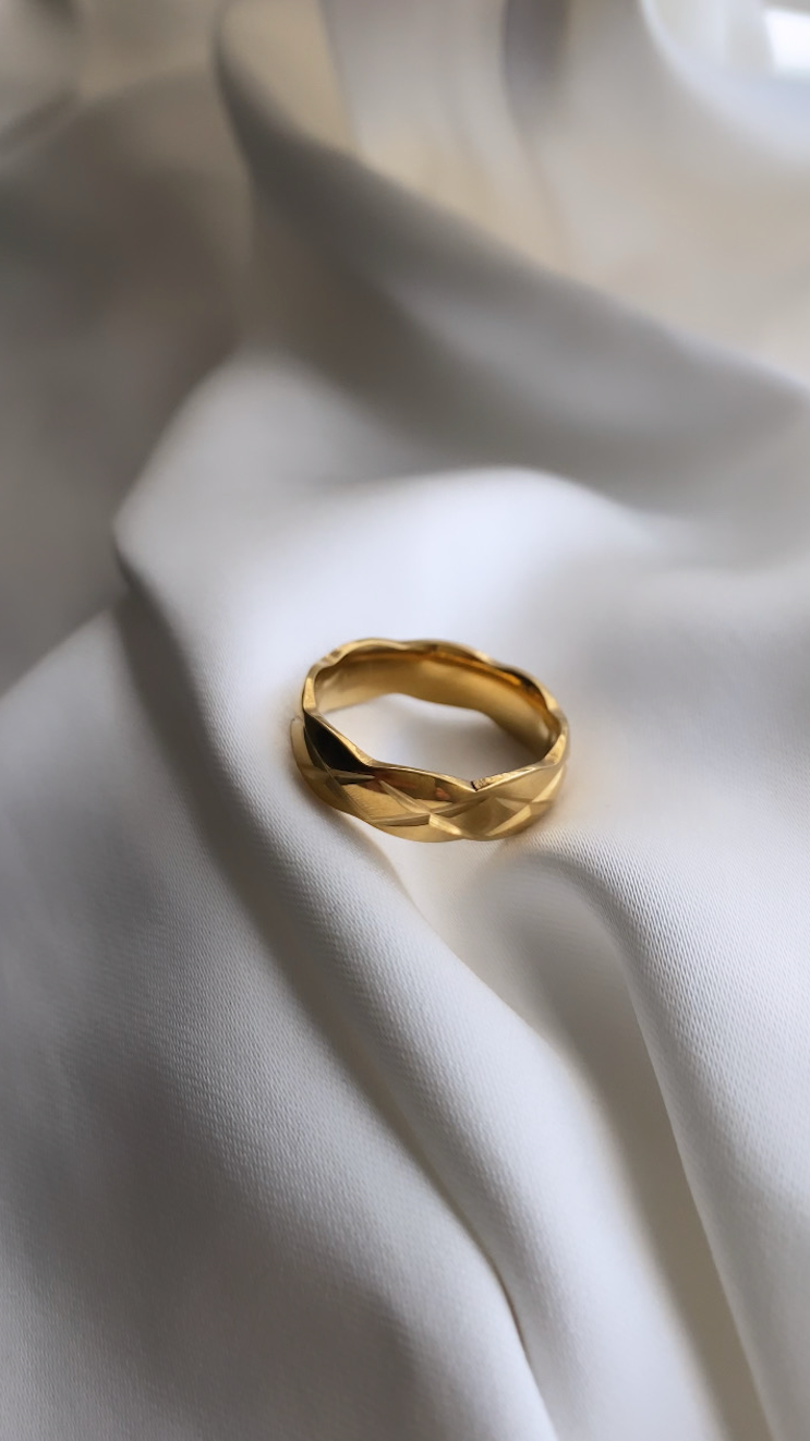 Gold ring on a white fabric surface