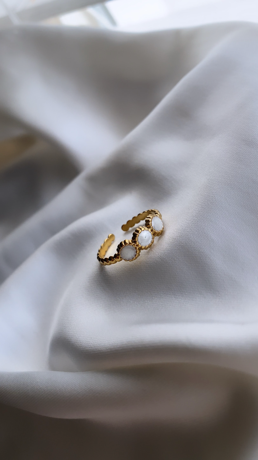 Gold ring with pearls on a white fabric background